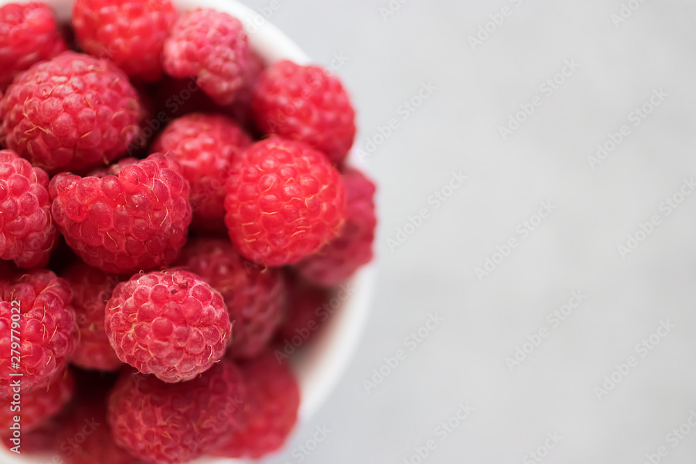 Ripe organic raspberries on gray background. Close-up. Soft focus. Ripe organic raspberries on gray background. Close-up. Soft focus.