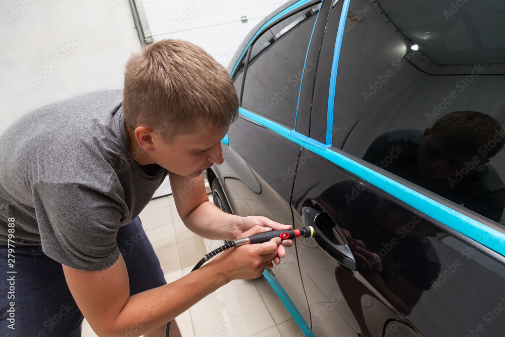 The polisher polishes the body of the vehicle with special wax to