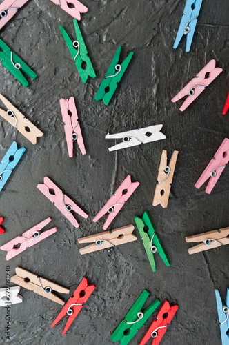 Hand made background, lot of colorful wooden clothespins on dark gray concrete, copy space