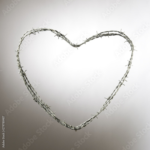 Barbed wire in heart-shaped. Copy text space. Isolated on grey background. Studio Shot.