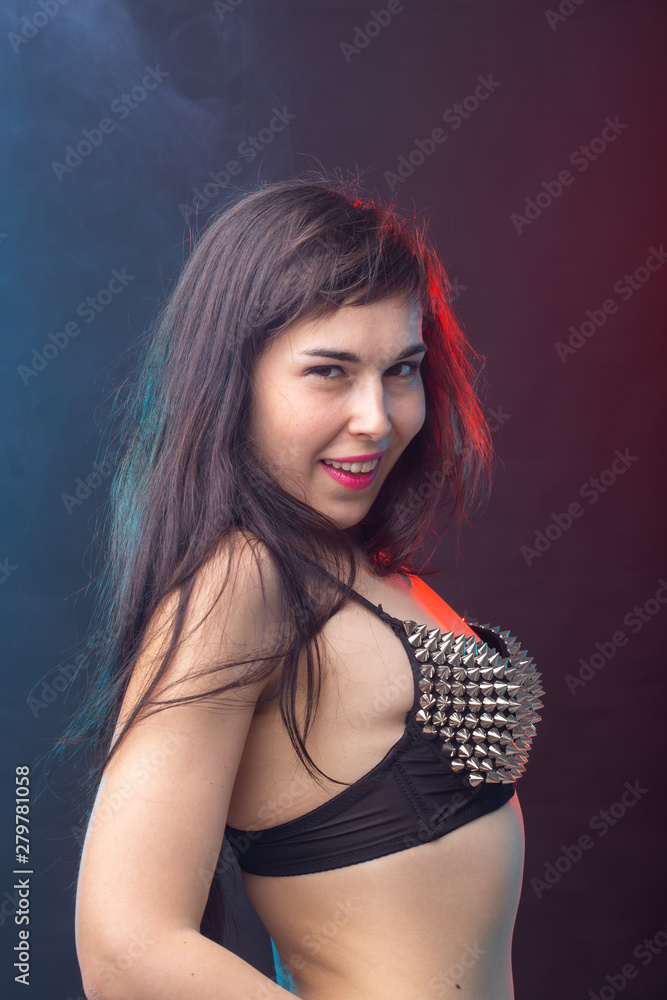 Fototapeta premium Alluring young beautiful brunette woman in a underwear posing on a dark background. Concept of seduction and sexual attractiveness
