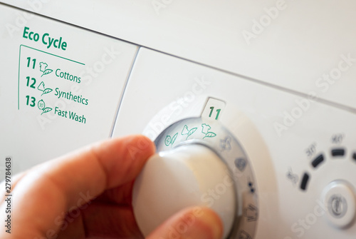 Canvas Print Close up of hand selecting green eco cycle programme on washing machine