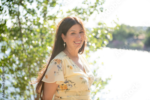 Pretty woman posing in the park by the lake