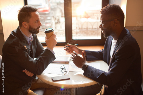 Two businessmen having a coffee break in the cafe.