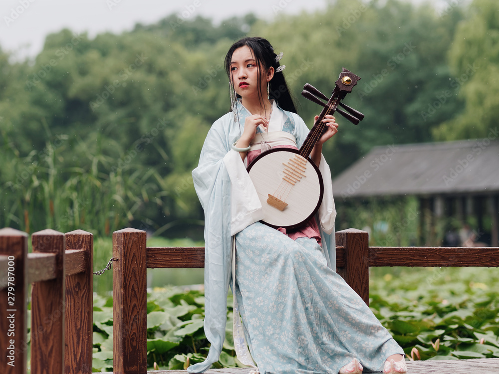 Beautiful Asian woman in cyan costume clothes hanfu holding yueqin ...