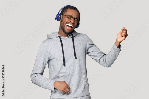 Excited black man in headphones have fun enjoying music