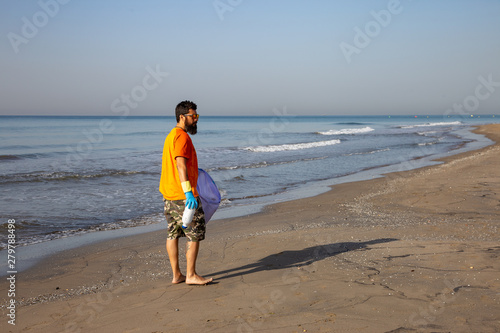 person looking for trash on the beach