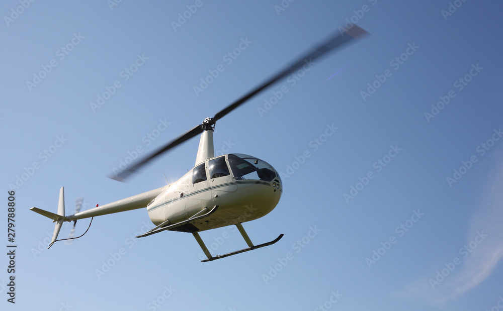 The aircraft - White small helicopter makes flight low height The aircraft - White small helicopter makes flight low height