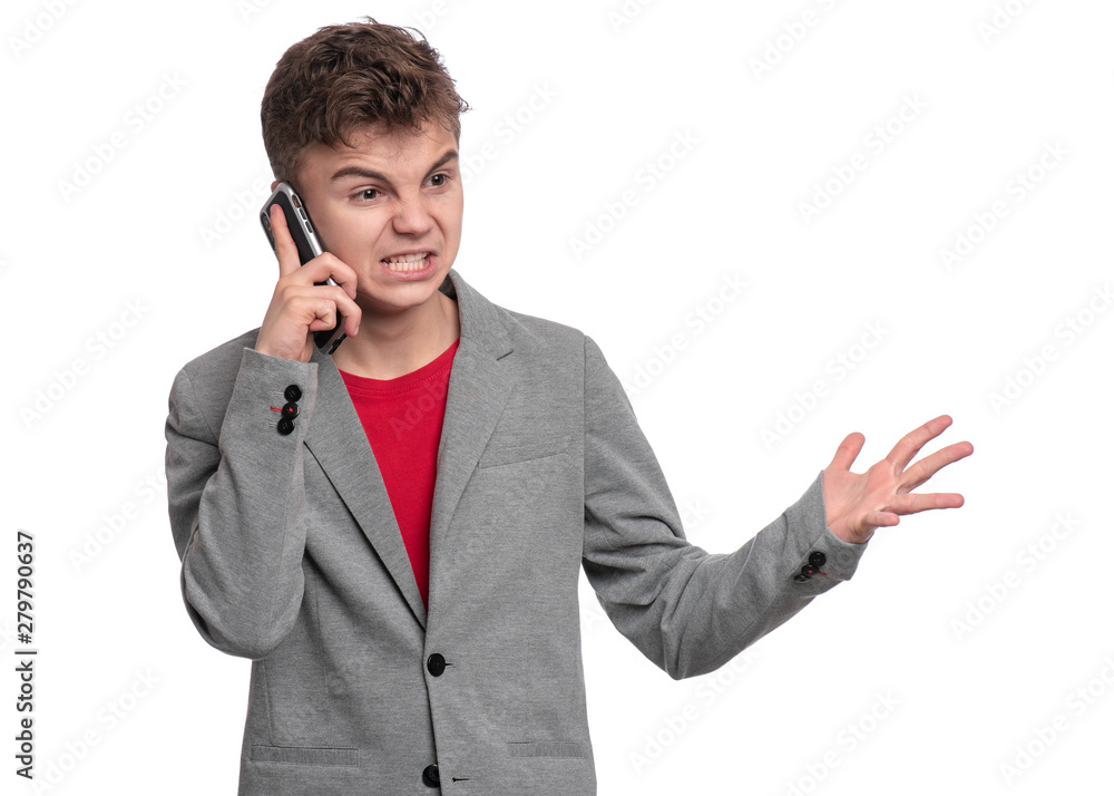 Portrait of Handsome Angry Teen Boy talk to Mobile Phone, isolated on white background. Child standing and using Cell Phone. Cute modern Teenager in suit with Smartphone. Portrait of Handsome Angry Teen Boy talk to Mobile Phone, isolated on white background. Child standing and using Cell Phone. Cute modern Teenager in suit with Smartphone.