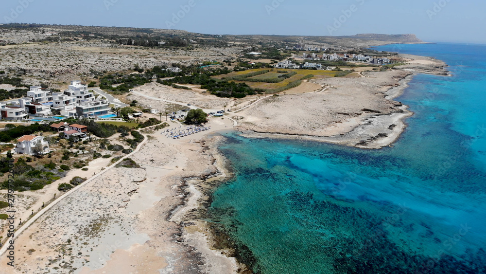 Obraz premium The rocky coast of Cyprus with azure water near Ayia Napa. Flying drone over the sea