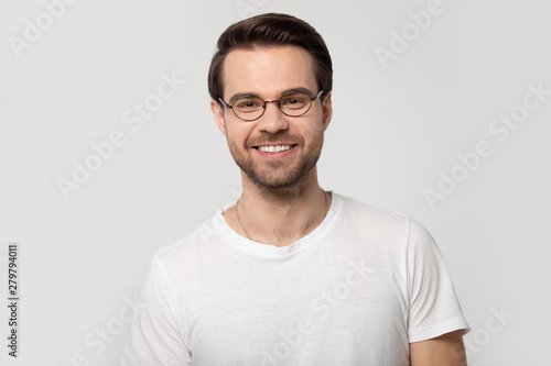Headshot portrait smiling man wearing glasses isolated on grey background © fizkes