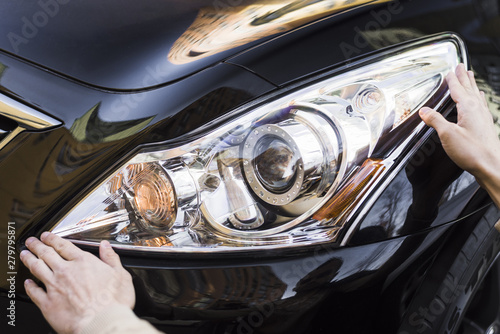 Billede på lærred Hand holding headlight of black car