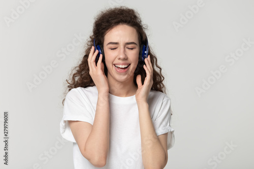 Girl wearing headphones enjoy favourite song isolated on grey background