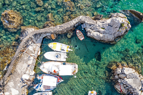 Aerial view of small boats at the marina. Beautiful rocky seashore with boats seen from above.