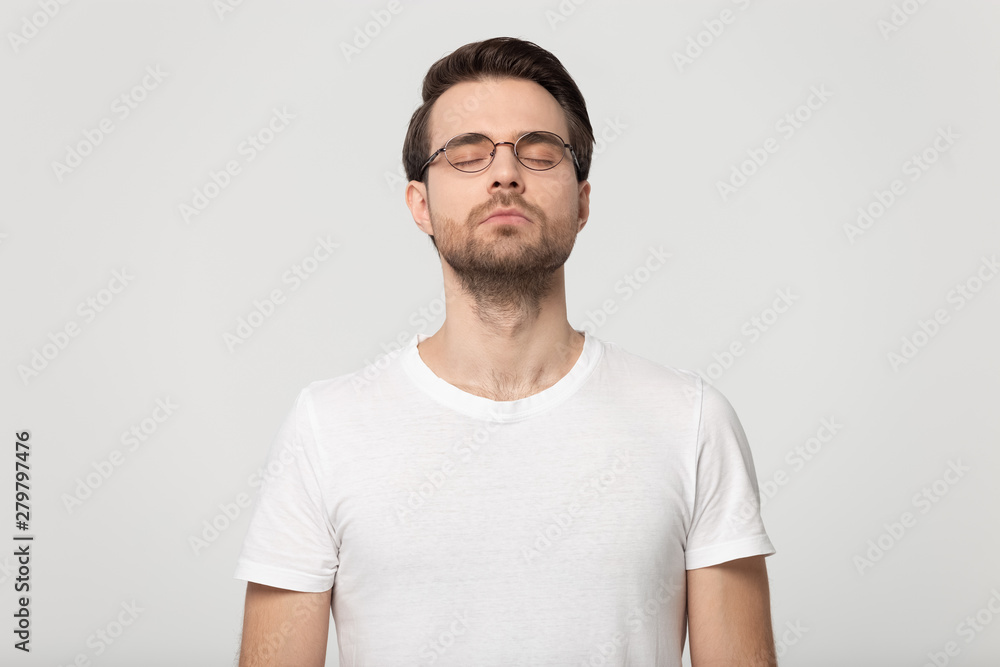 Young man closed eyes dreaming isolated on grey studio background Young man closed eyes dreaming isolated on grey studio background