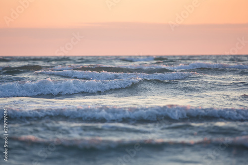 Obraz na plátně White horses sea waves at soft orange sunset