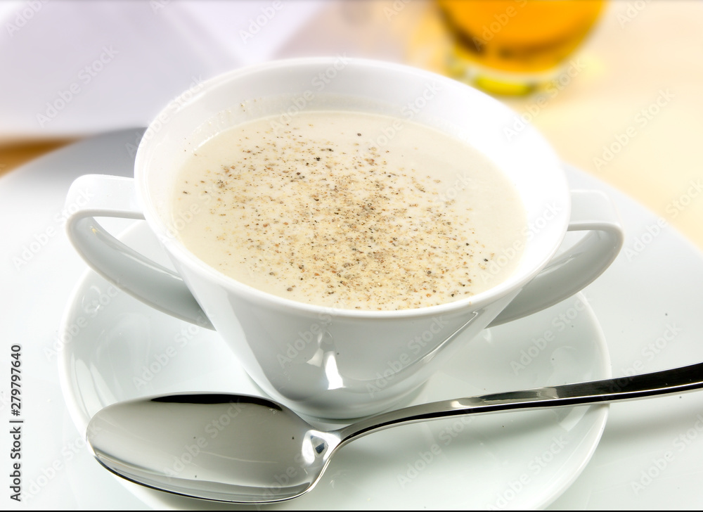 Vichyssoise en taza con cuchara sobre mesa. Vichyssoise in cup with spoon on table. Vichyssoise en taza con cuchara sobre mesa. Vichyssoise in cup with spoon on table.