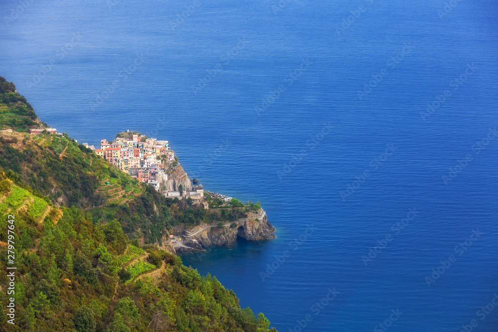 Seacoast with deep blue sea and village with colorful houses on the slope in Cinque Terre, the Liguria region