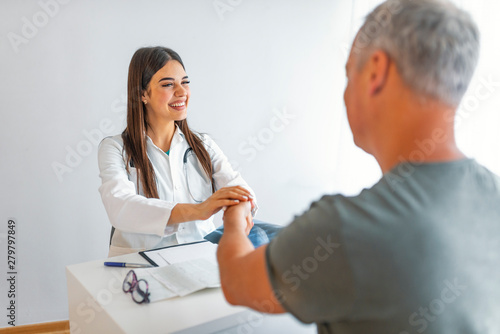 Medicine and health care concept  Professional Male doctor in white coat handshake with patient after successful recommend treatment methods. Patient cheering and support