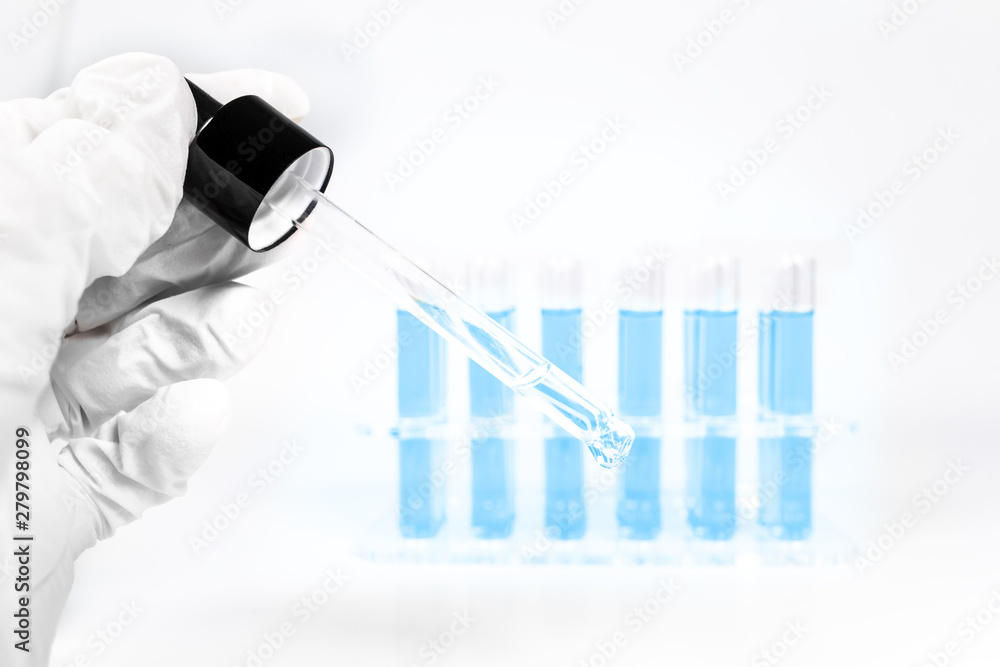 Φωτογραφία Chemie Reagenzglas mit blauer Flüssigkeit mit Pipette und Reagenzgläsern im Hint