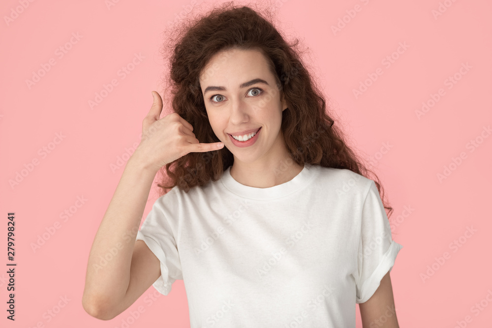 Smiling woman showing call me gesture with fingers studio shot Smiling woman showing call me gesture with fingers studio shot