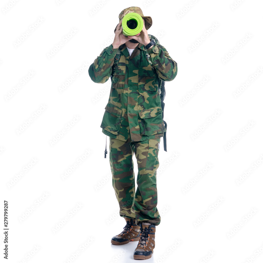 Man in camouflage clothes with backpack hiking standing looking on white background isolation Man in camouflage clothes with backpack hiking standing looking on white background isolation