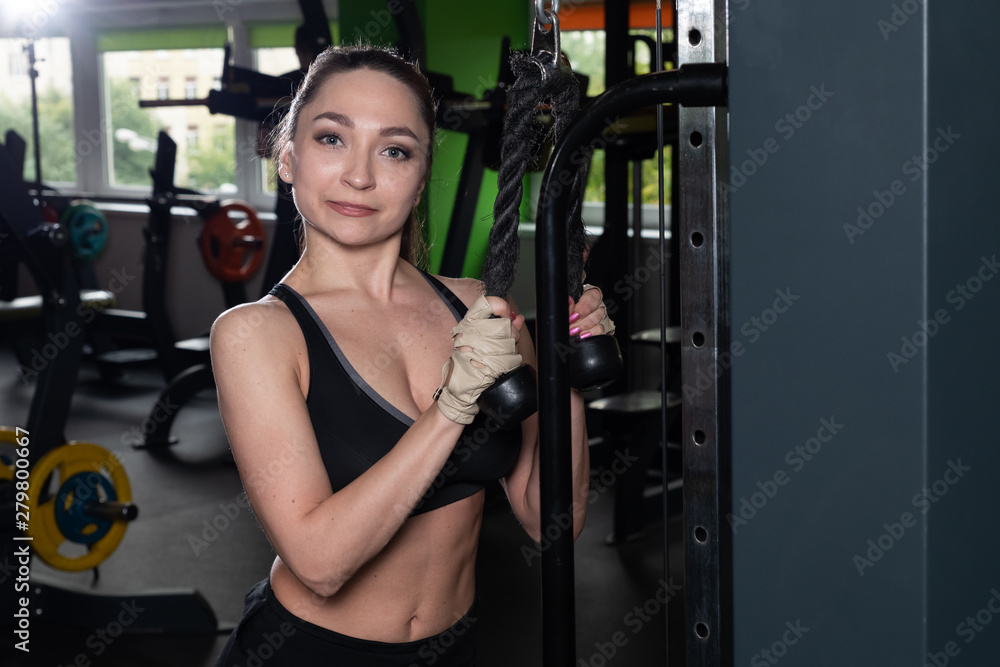 young fitness woman execute exercise with exercise-machine Cable Crossover in gym, horizontal photo young fitness woman execute exercise with exercise-machine Cable Crossover in gym, horizontal photo