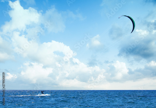 kitesurfing riding over a surface of the Mediterranean sea with