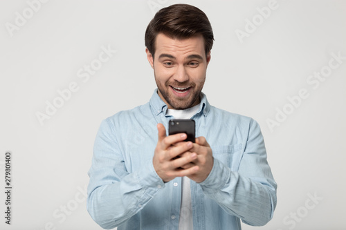Man holding looking at smartphone feels surprised studio shot