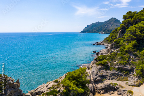 Aerial view of the ocean and rocks and stones. Beautiful sunny coast seen from above.