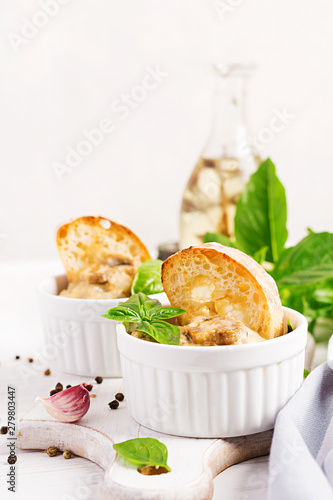 Baked mushroom julienne with chicken, cheese and toast in pots.