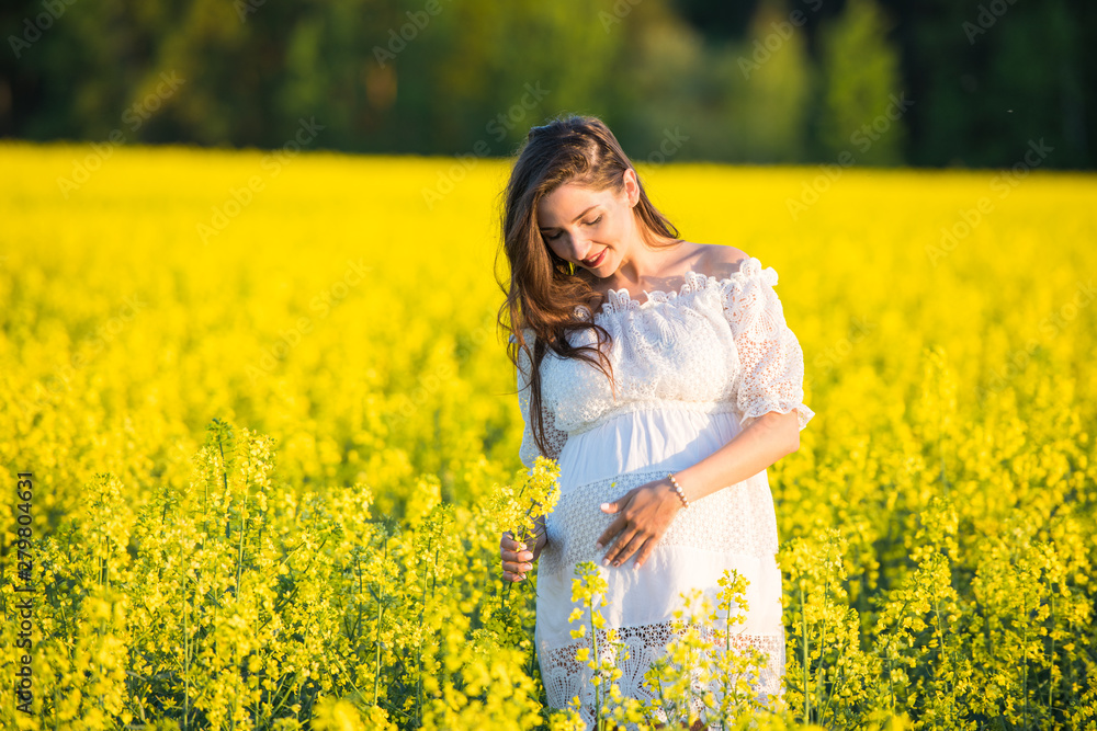 Pregnant girl on the rapeseed field. cute young woman waiting a baby Pregnant girl on the rapeseed field. cute young woman waiting a baby