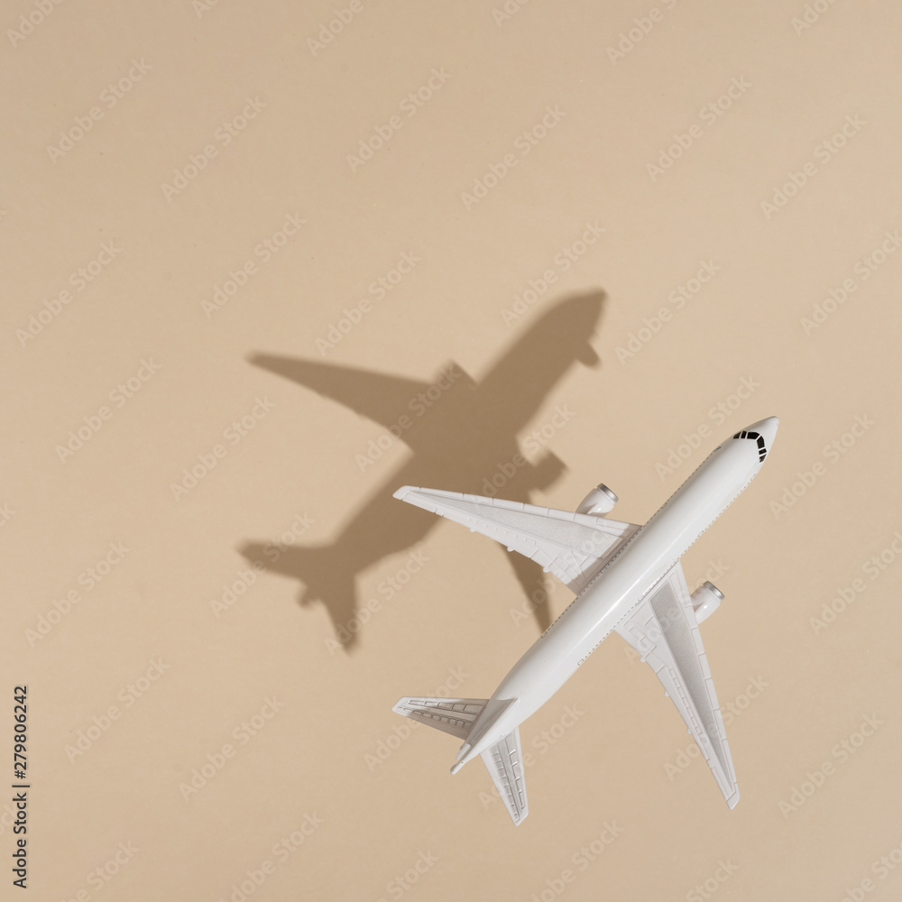Top view of airplane on sand color background. Flat lay. Minimal summer travel concept. Creative copy space. Top view of airplane on sand color background. Flat lay. Minimal summer travel concept. Creative copy space.