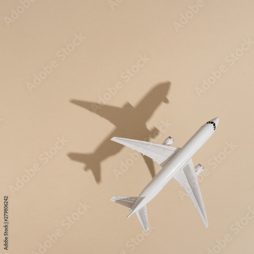 Top view of airplane on sand color background. Flat lay. Minimal summer travel concept. Creative copy space.
