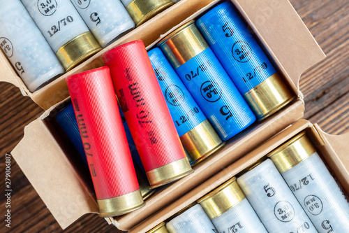 12 gauge caliber color cartridges hunting shells in a box pack on a brown wooden background photo