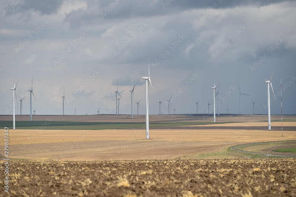 Wind turbines in a wind farm with a dramatic stormy sky in the background