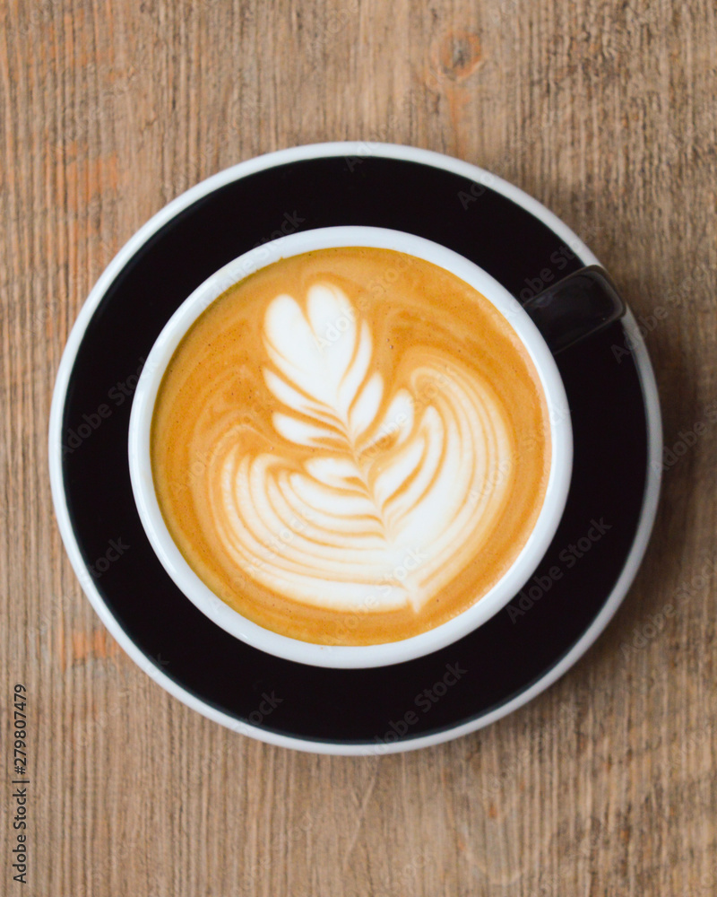 Cappuccino mit Latte Art auf einem Holztisch Cappuccino mit Latte Art auf einem Holztisch