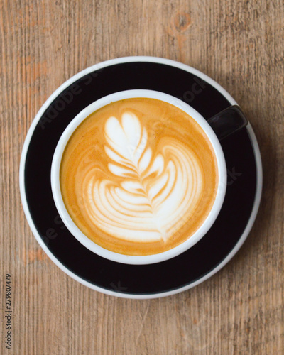 Cappuccino mit Latte Art auf einem Holztisch