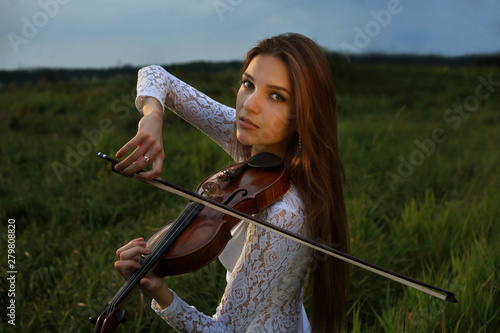 Girl with violin in the forest