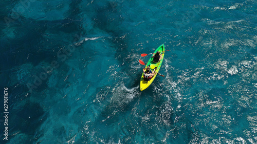 Aerial photo of fit athletes competing on sport canoe in tropical exotic bay with crystal clear turquoise sea