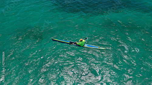 Aerial drone photo of fit men practising sport canoe in tropical open ocean bay with turquoise clear sea