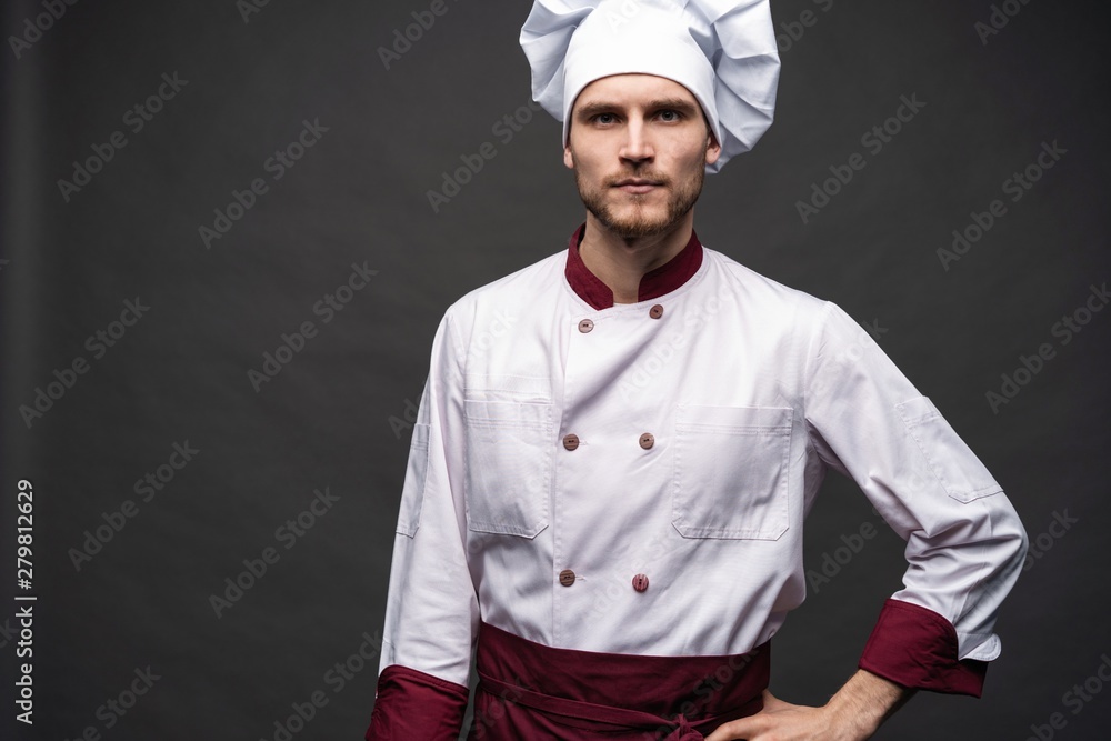 Young male chef isolated on a black background.