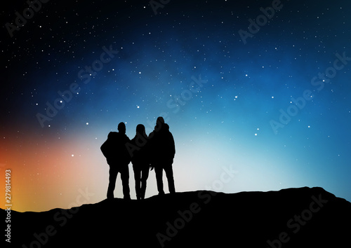 travel  hike and success concept - group of travelers or friends standing on edge of hill over starry night sky or space background