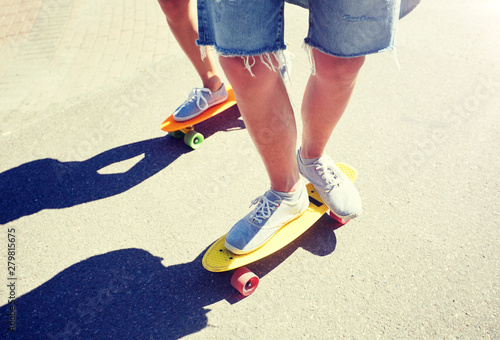 summer, extreme sport and people concept - teenage couple riding short modern cruiser skateboards on city road © Syda Productions