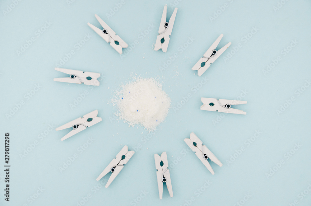 Flat-lay white clothes pins surrounding detergent