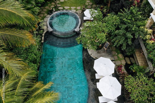Top view of luxury round pool with white umbrellas and sun beds in tropical jungle and palm trees. Luxurious villa, swimming pool in forest, Ubud, Bali © tatyanasuyarova