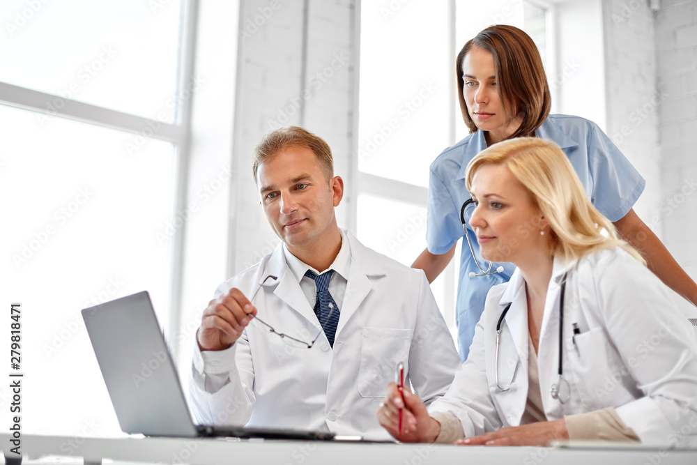 healthcare, medicine and technology concept - group of doctors with laptop computer at hospital healthcare, medicine and technology concept - group of doctors with laptop computer at hospital