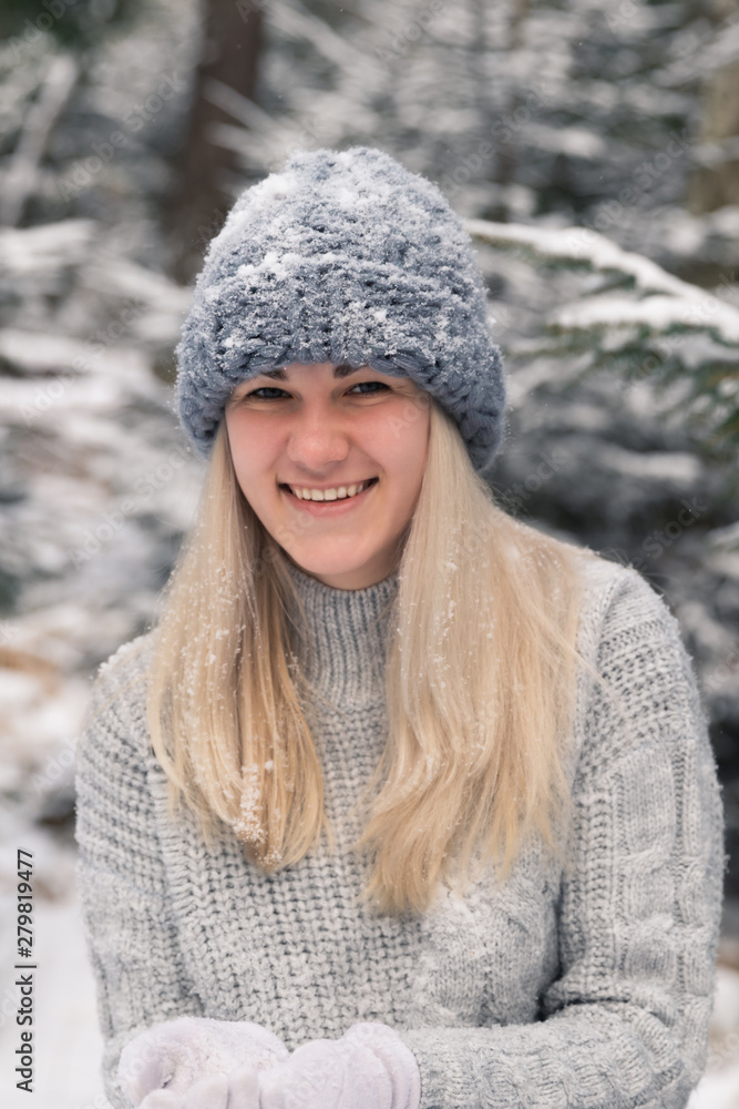 Young beautiful girl with long white hair plays snowballs. She has fun, throws snow and rejoices the snowfall. Winter walk outside. Young beautiful girl with long white hair plays snowballs. She has fun, throws snow and rejoices the snowfall. Winter walk outside.