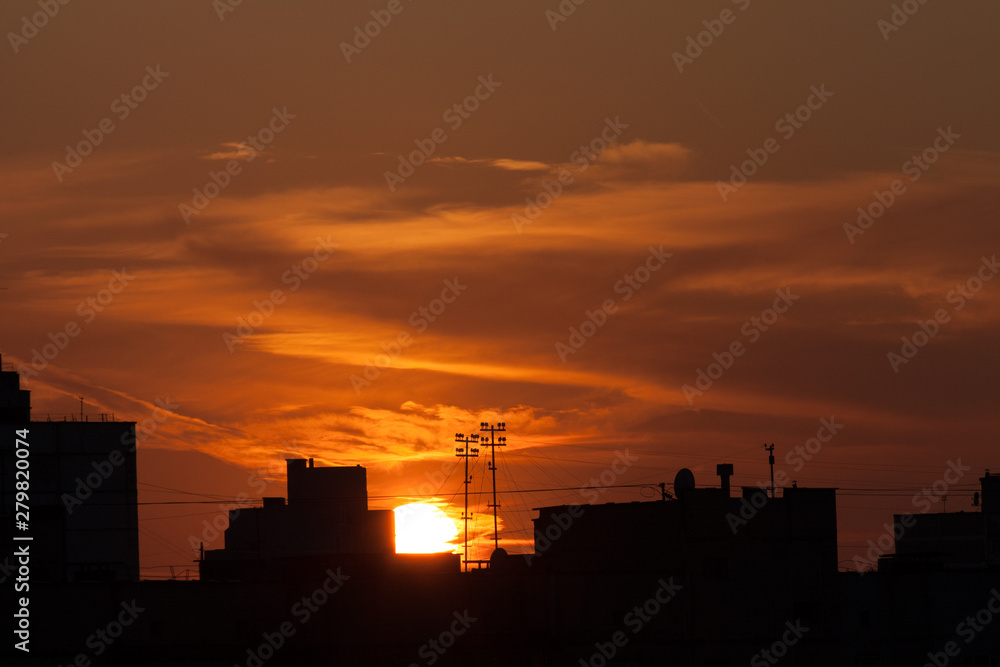 Town silhouette at sunset with buildings and colorful sky. Blurred background Town silhouette at sunset with buildings and colorful sky. Blurred background