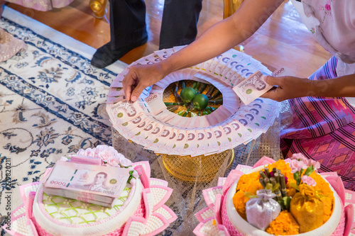 Tableau sur toile Focus bride price in Thai wedding ceremony, gold necklace, thai banknote and wedding rings